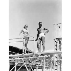  A Man and a Young Woman Stand on a Diving Board in Their 